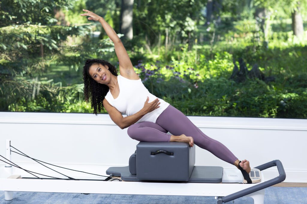 Person on a reformer during an online Pilates class